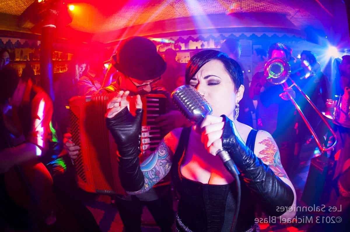 Tattooed vocalist and accordion player performing at The 7 Deadly Sins
