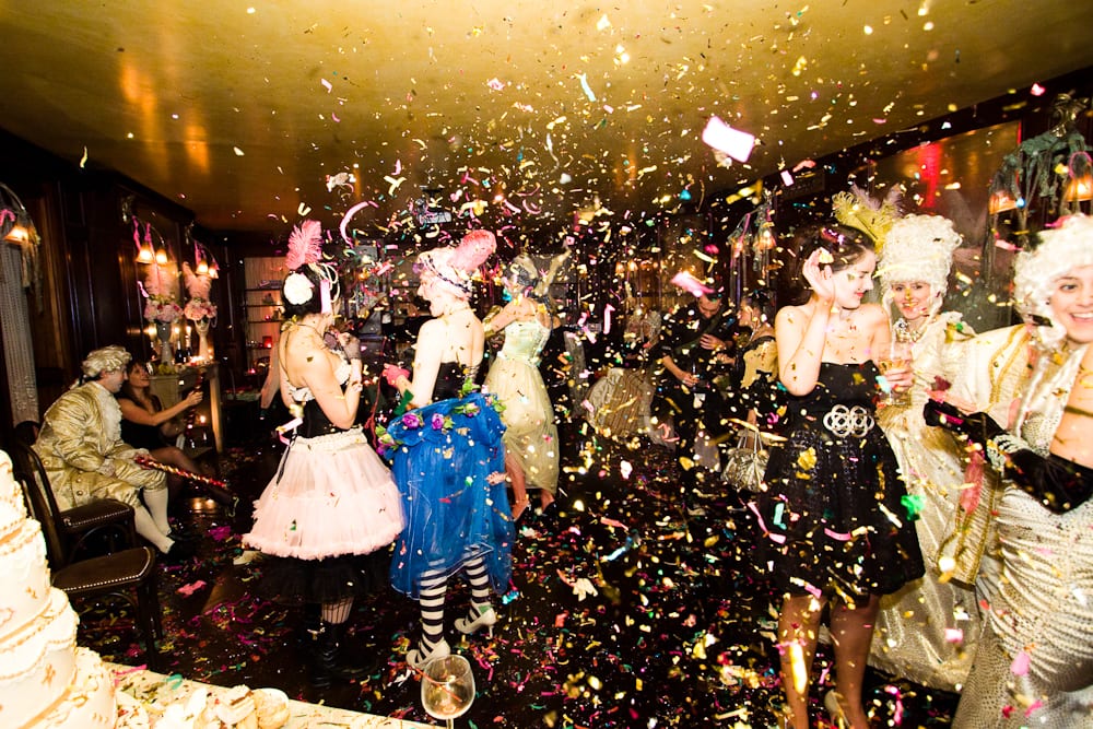 Marie Antoinette-themed dancers in period costume under confetti