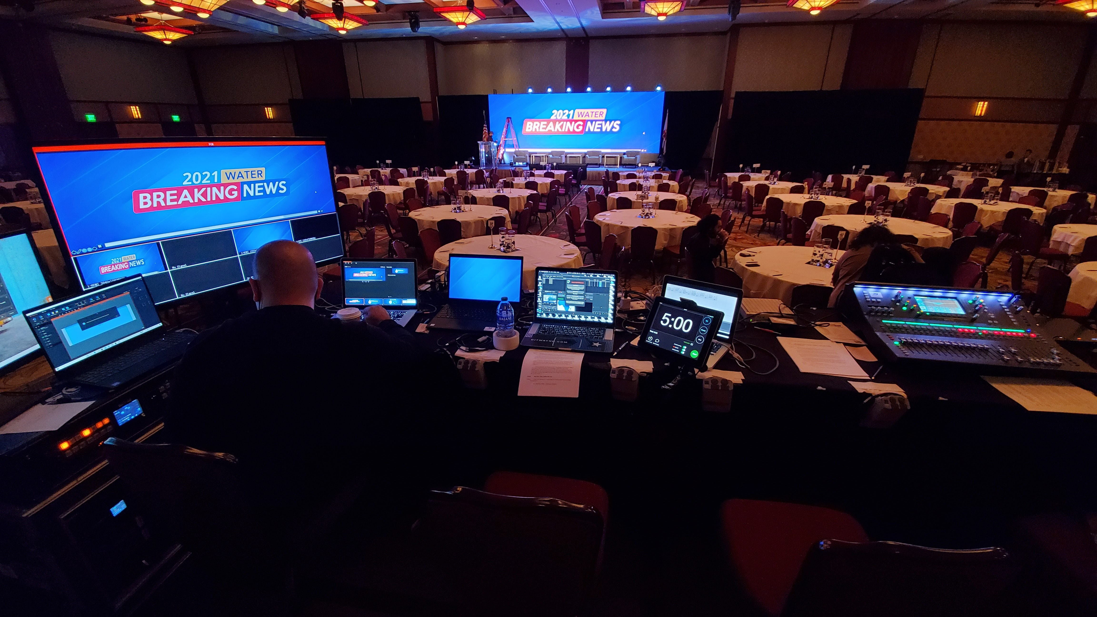 Front-of-house audio mixing console lit in blue