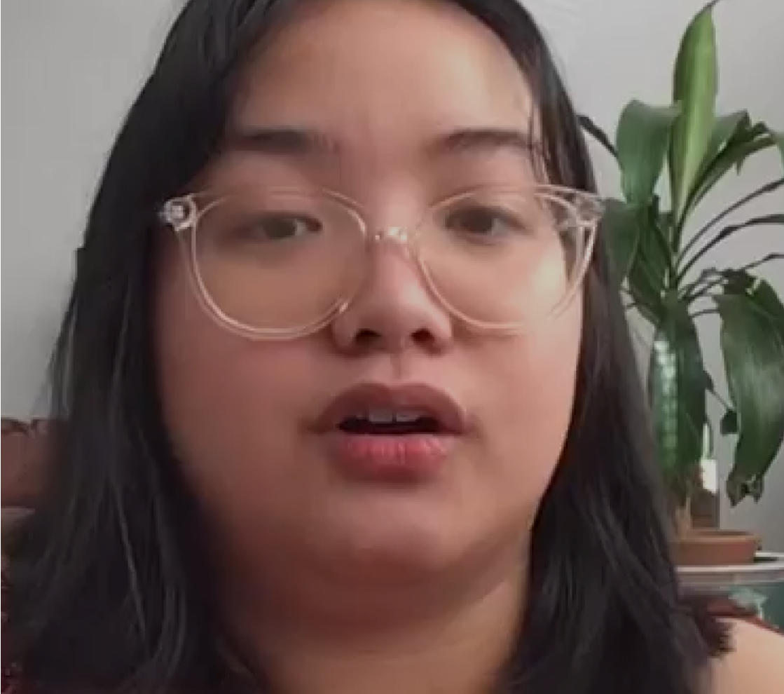 Client testimonial — woman in clear-framed glasses