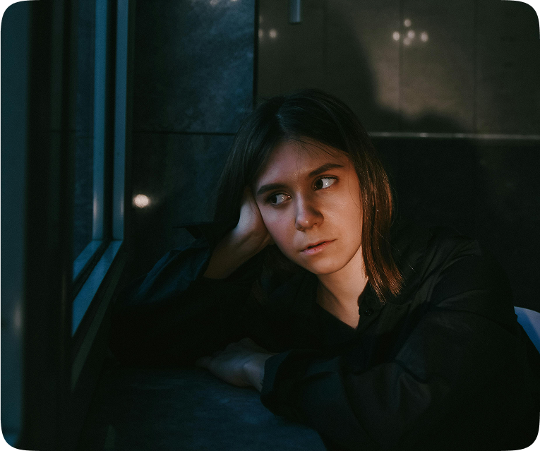 Pensive woman in a dark room