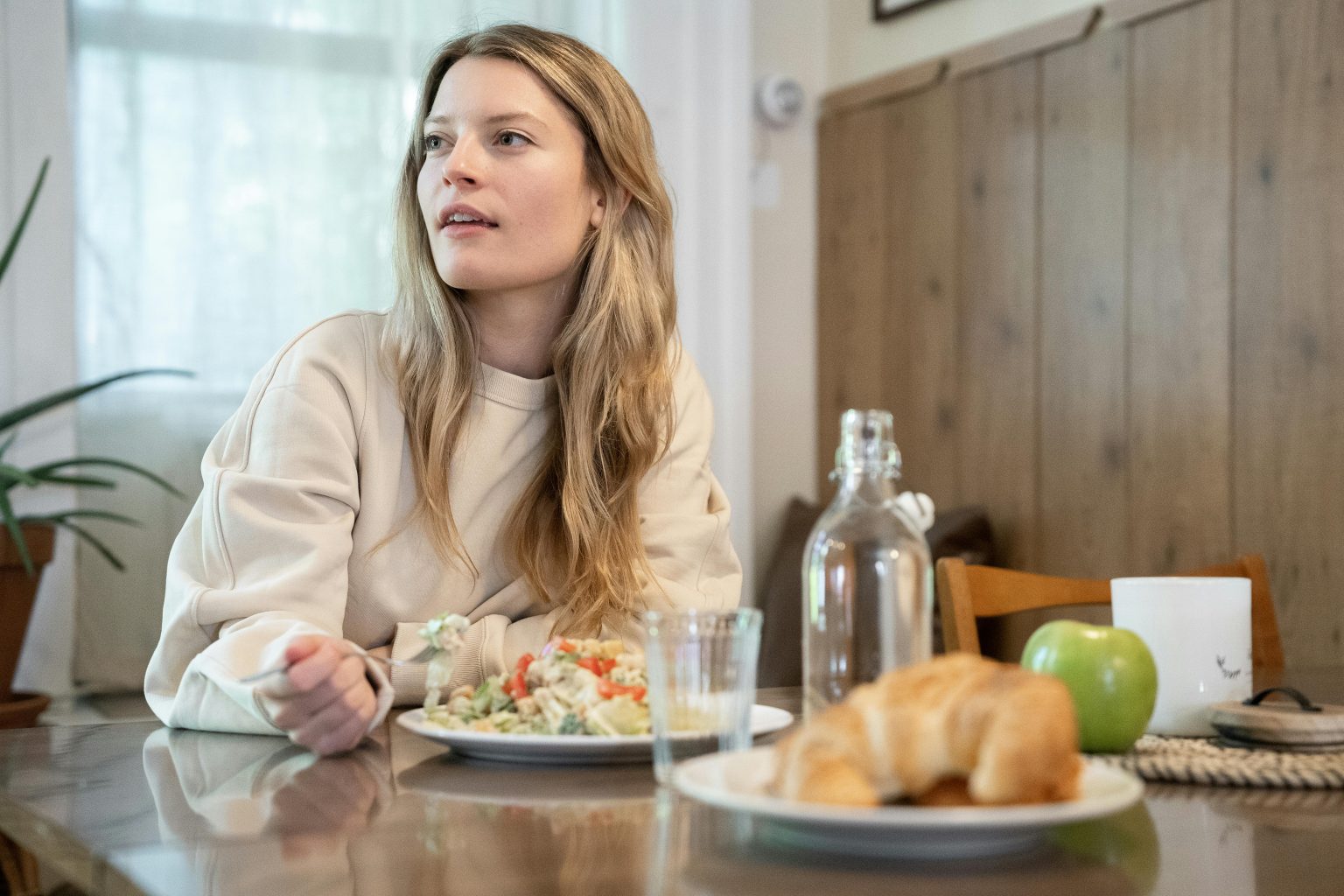 Woman eating a nourishing meal in warm window light