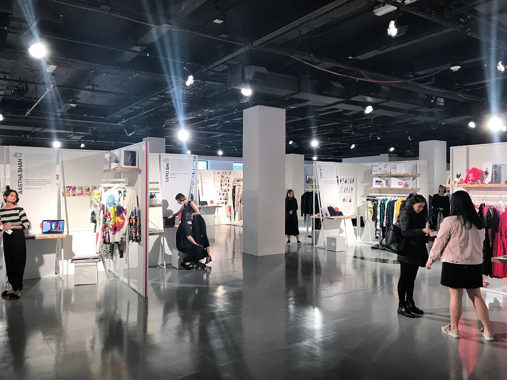 CFDA fashion trade show setup with designer booths and clothing racks
