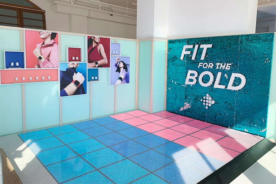 Fitbit product launch pop-up installation with branded wall and tile floor display
