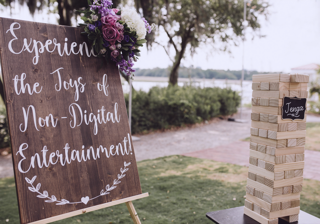 Outdoor wedding giant Jenga station with a 'non-digital entertainment' sign