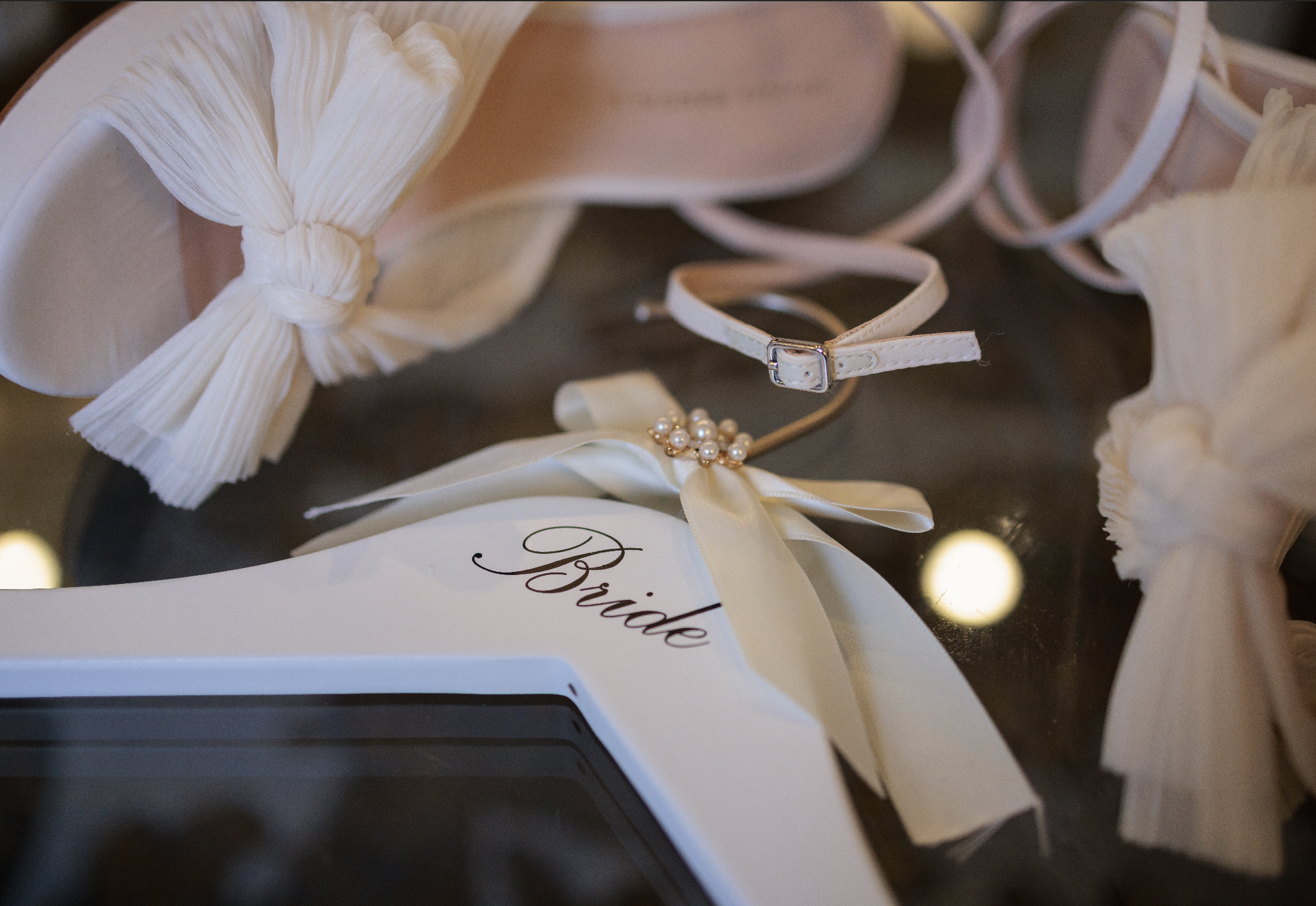 Wedding bridal accessories flat lay with 'Bride' hanger and pearl brooch