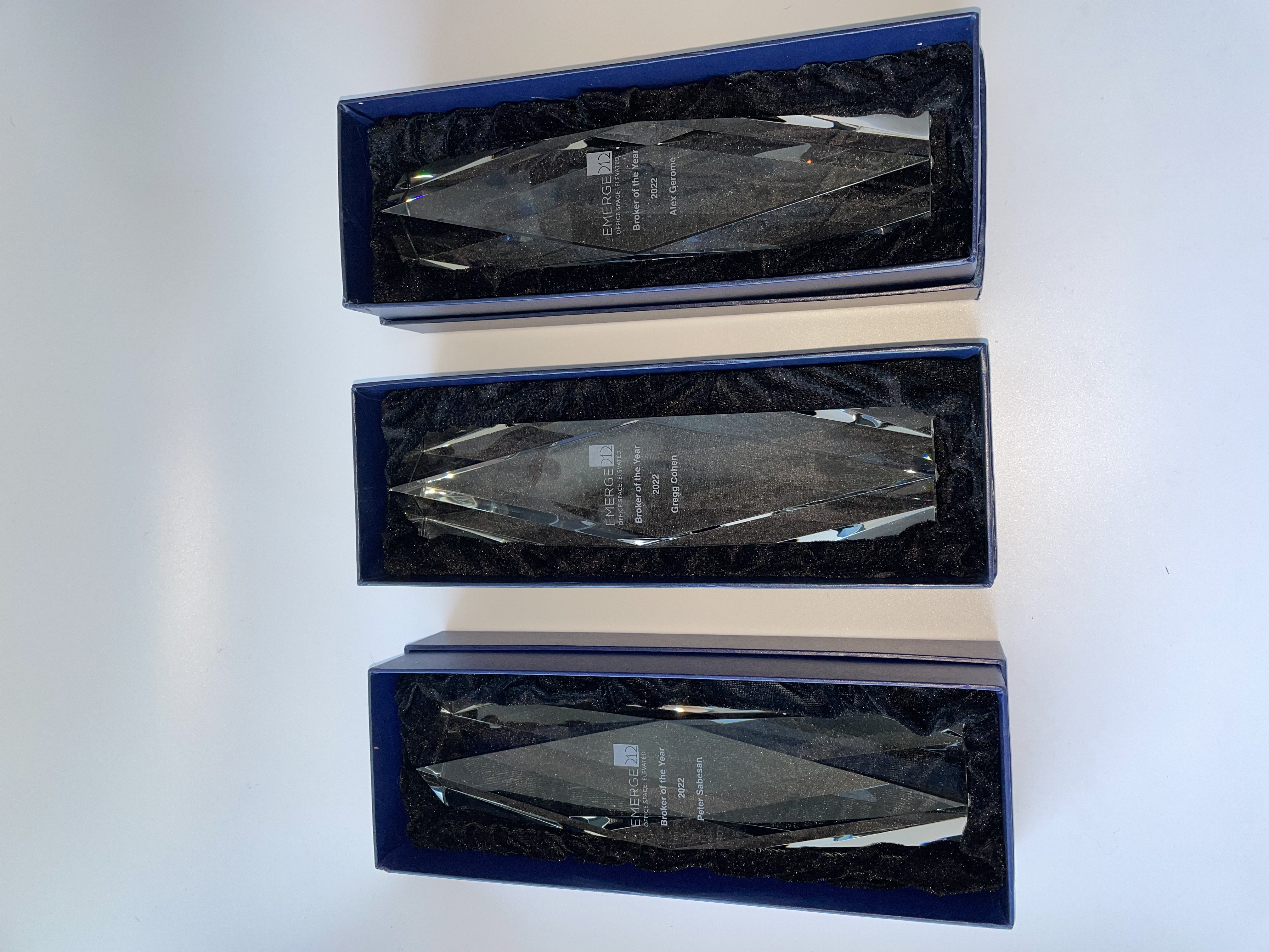 Three crystal 'Broker of the Year 2022' awards by Emerge212 in blue gift boxes