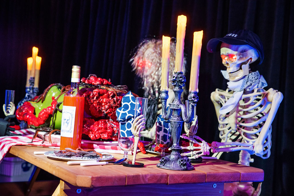 Moody Halloween-themed event table with skeleton prop and decorative skulls