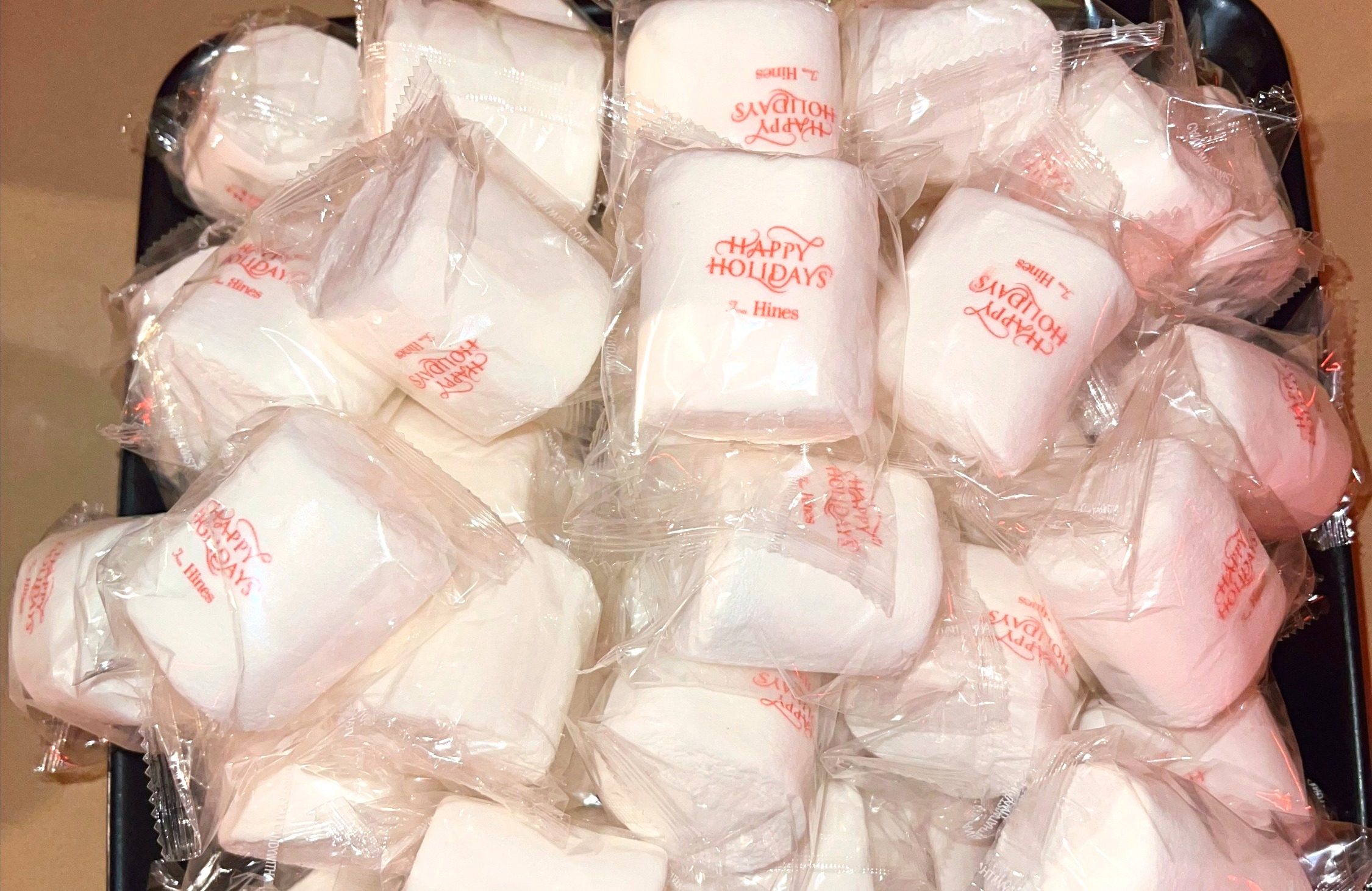 Custom branded oversized marshmallows wrapped in 'Happy Holidays – Hines' cellophane