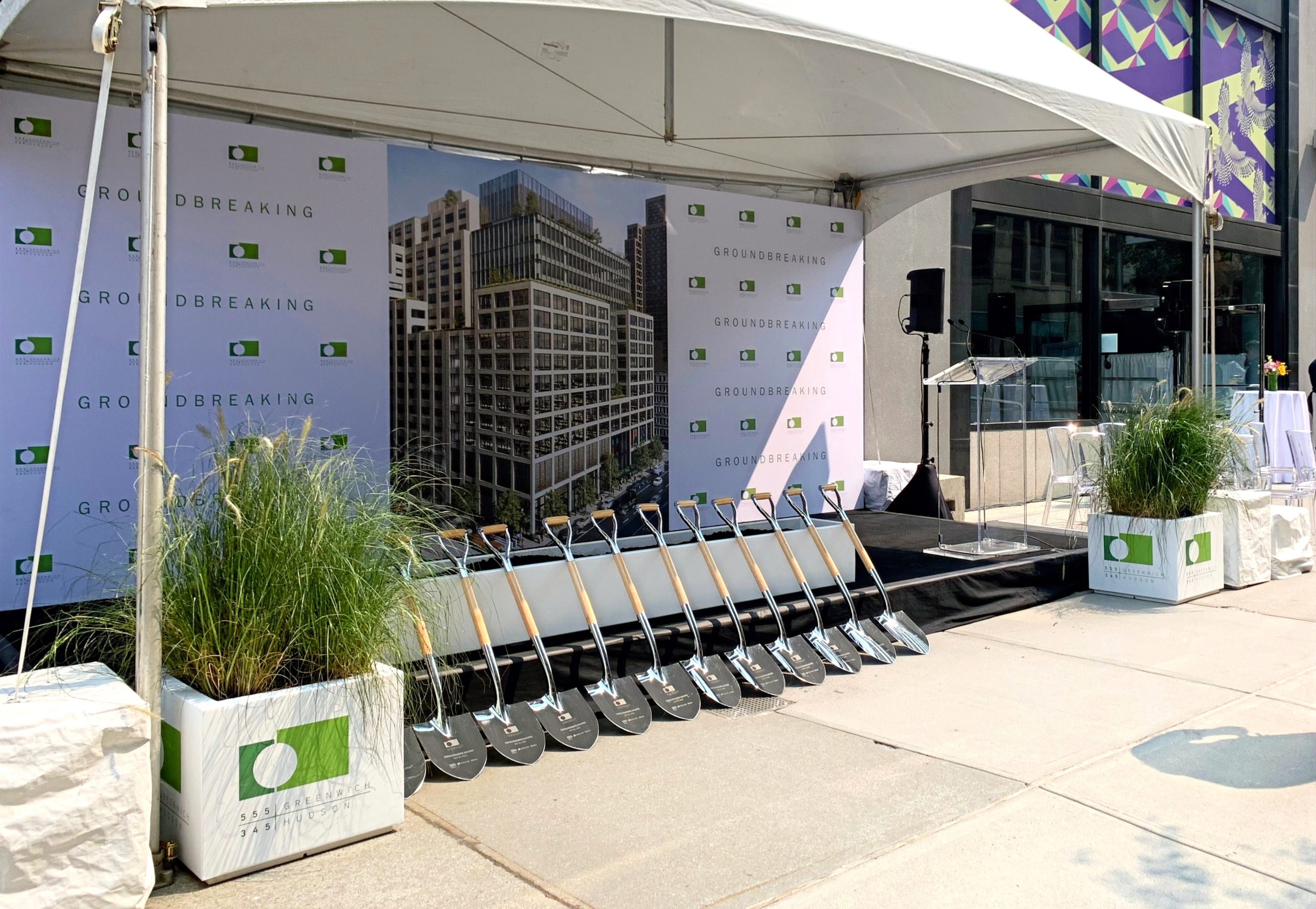 Groundbreaking ceremony setup with branded ceremonial shovels under a tent