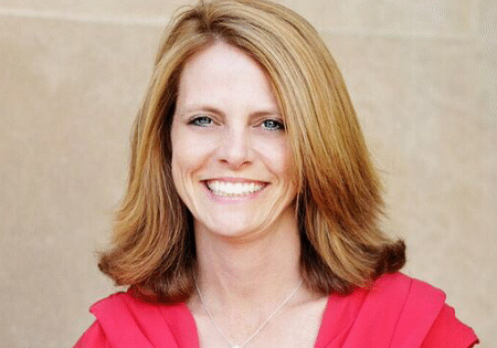 Amy Moran, smiling, wearing a red top
