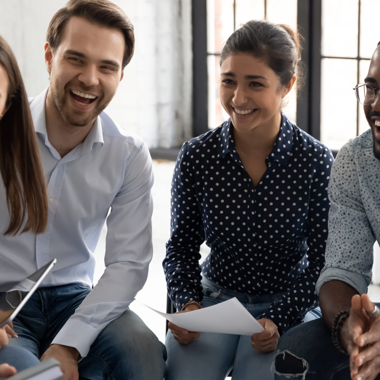 Diverse group of professionals laughing together in a circle session