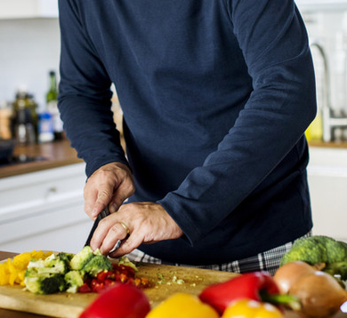 Hands chopping colorful vegetables on a cutting board