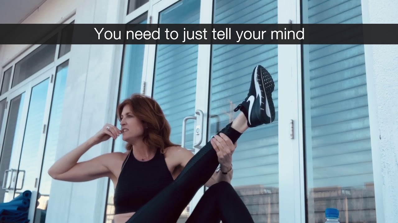 Andrea Marcellus doing a leg-lift exercise on a balcony