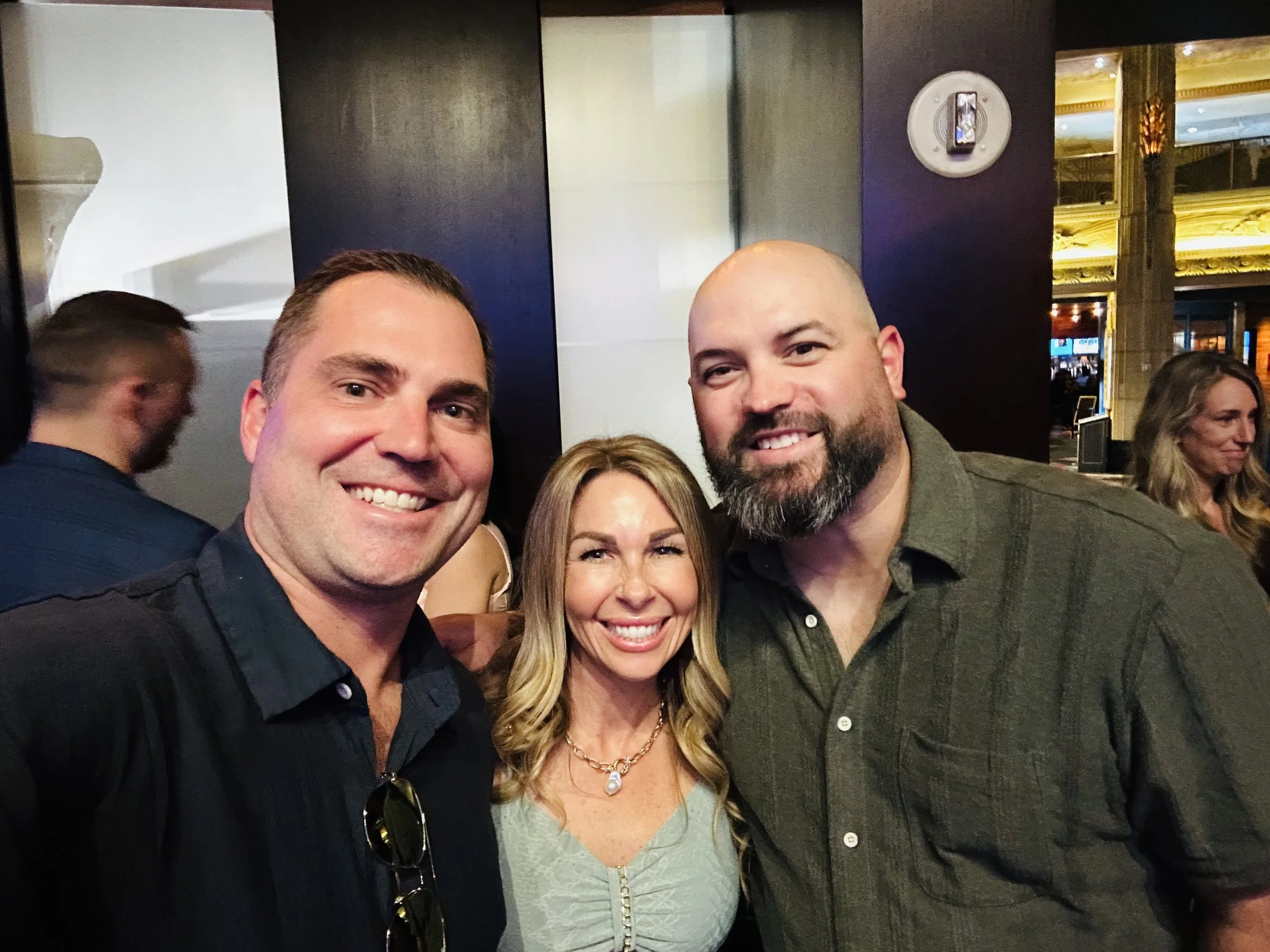 Three people smiling together at a casino event venue