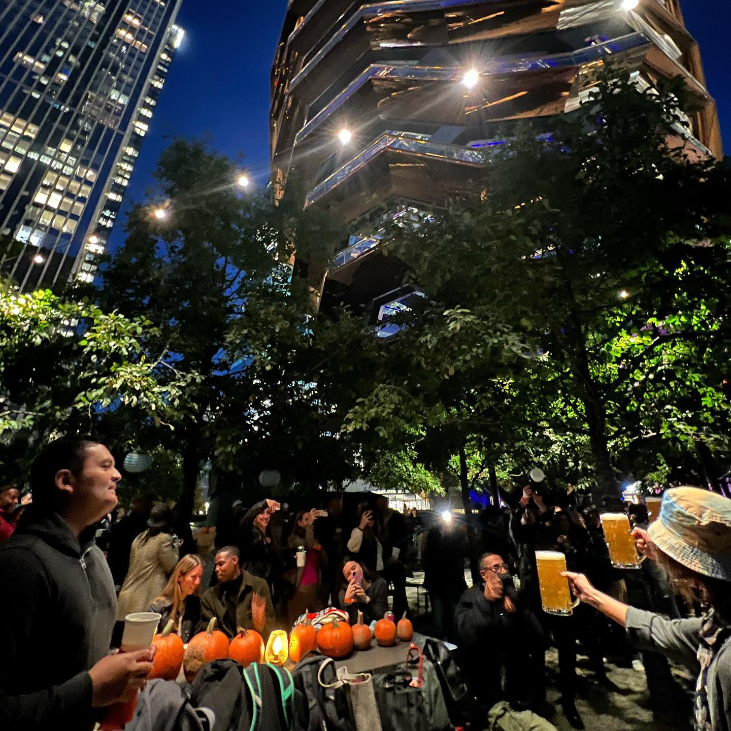 Nighttime gathering at Hudson Yards HarvestFest with the Vessel behind