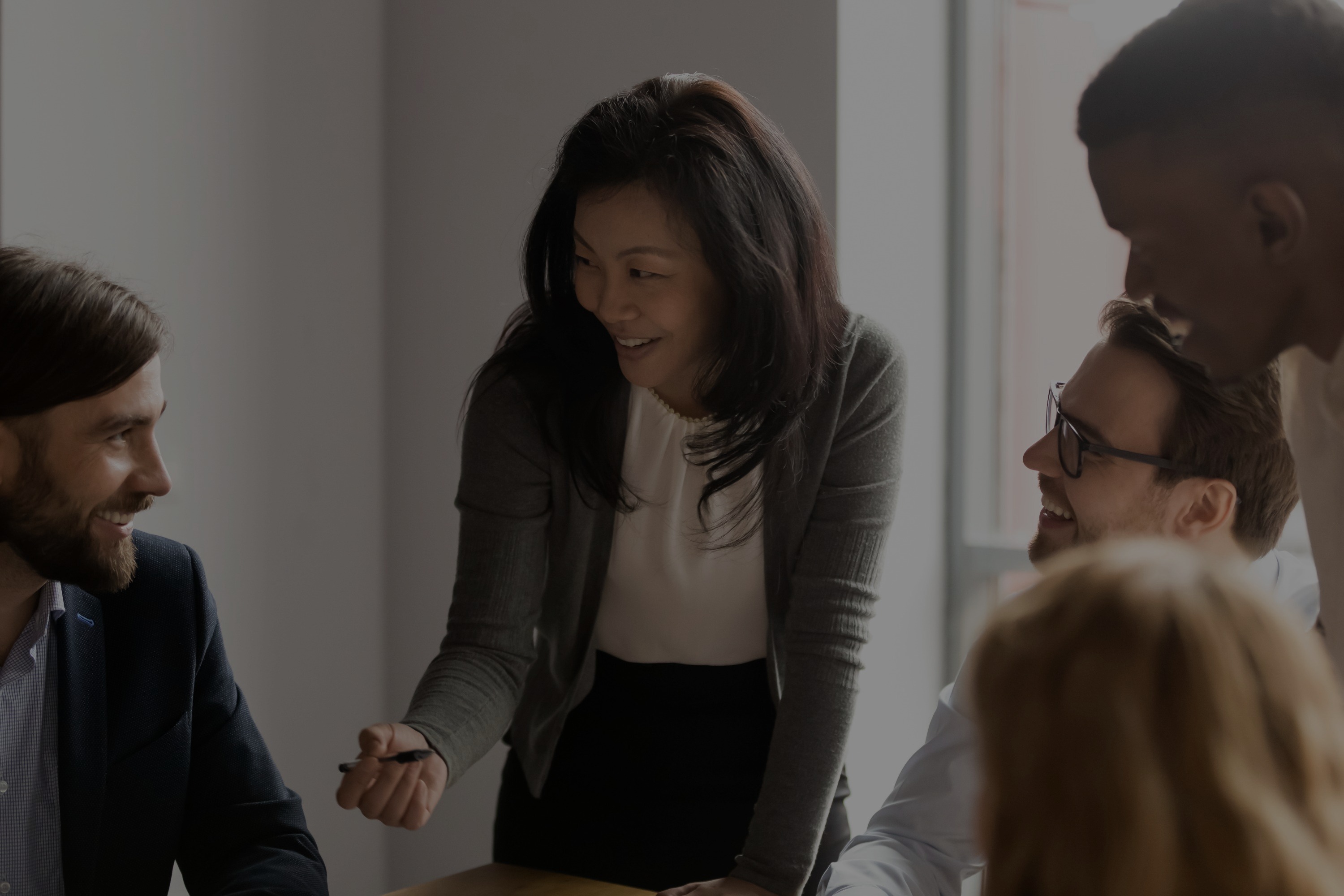 Team of five professionals collaborating around a conference table