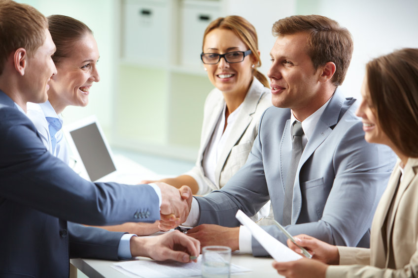 Group of business professionals shaking hands in a meeting