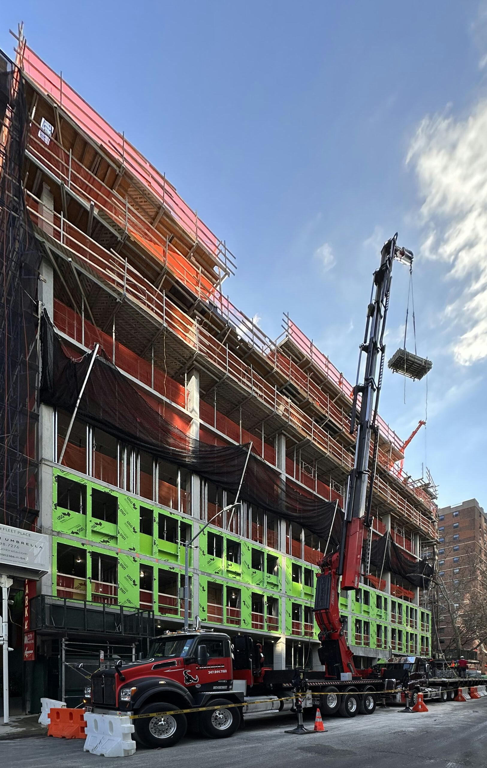 Active New York City construction site with scaffolding and a crane