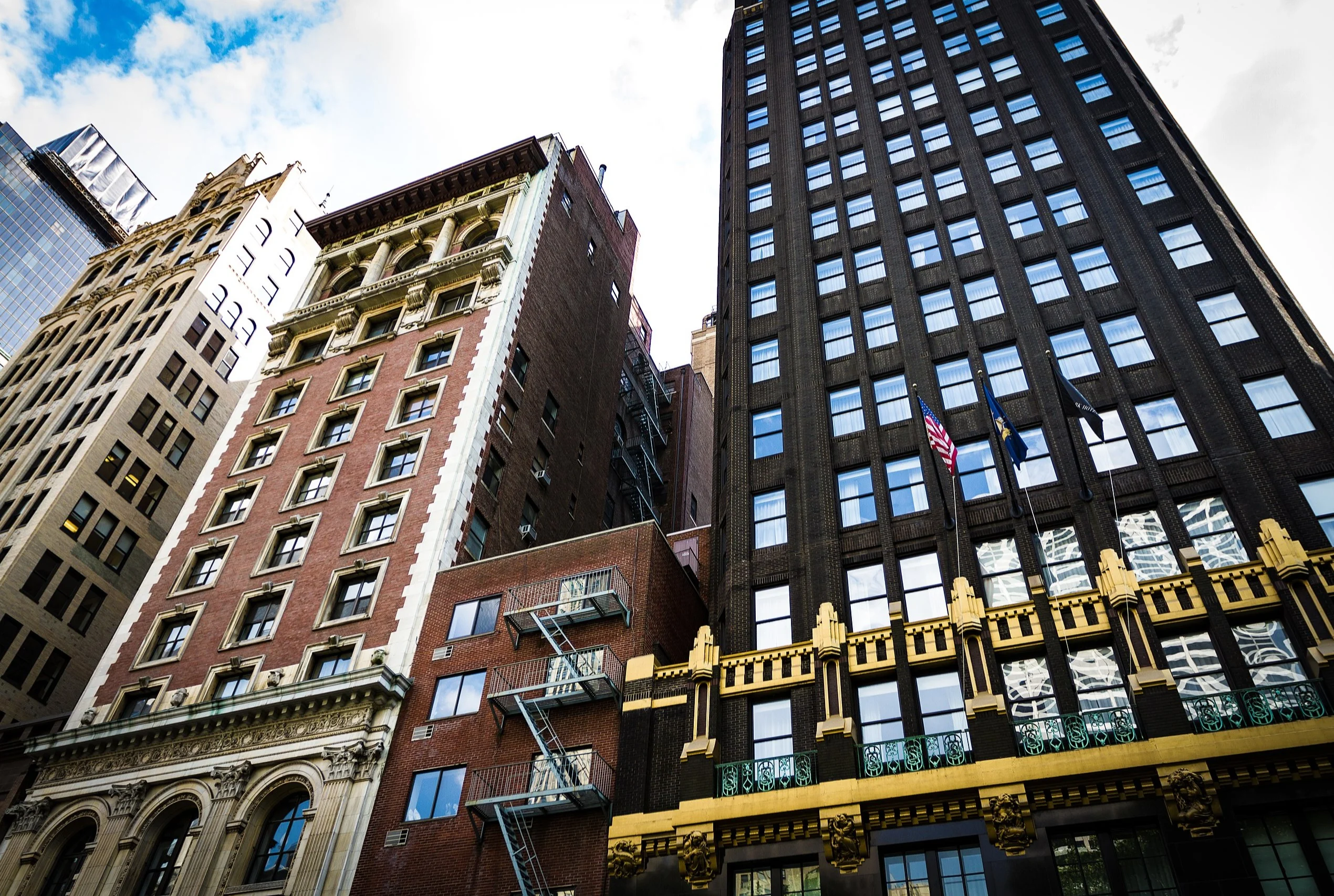 Low-angle view of historic brick and Art Deco building facades near Bryant Park, New York City