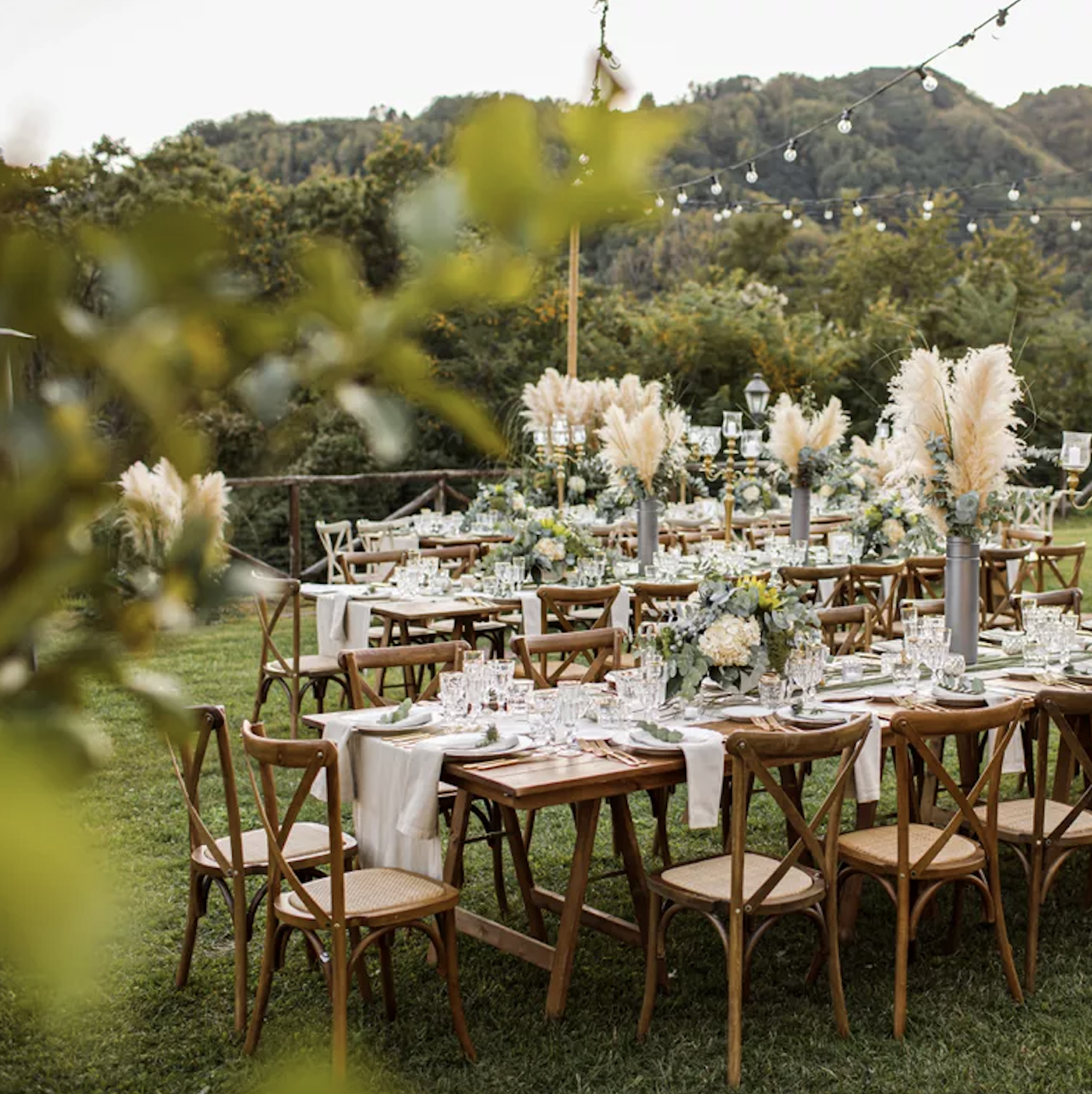 Mountain-backdrop reception with pampas grass centerpieces on long tables.