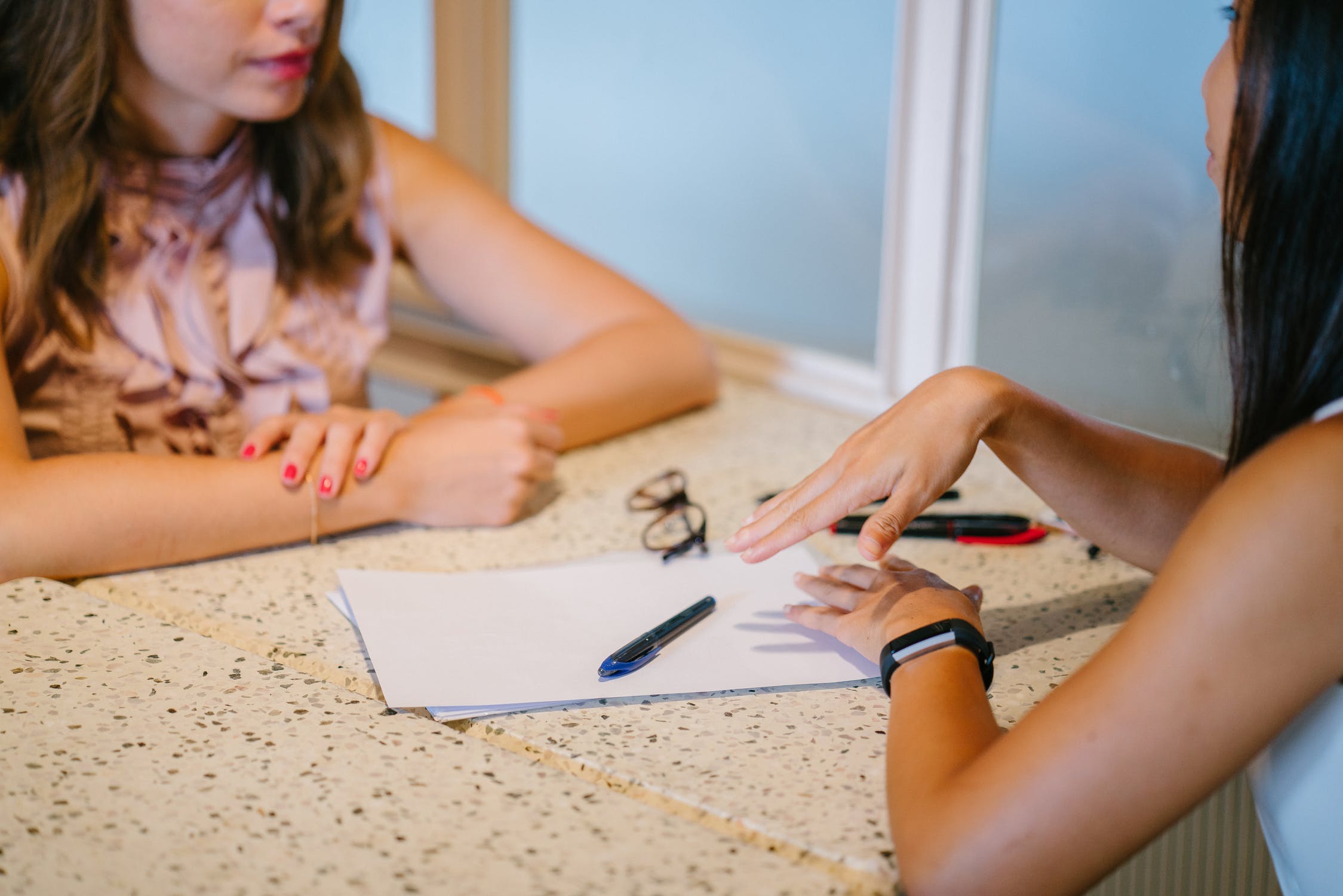 Two women in a coaching session at a table with papers