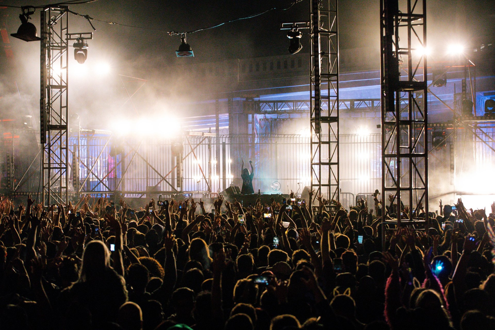 Outdoor night concert stage with large crowd and stage lighting.