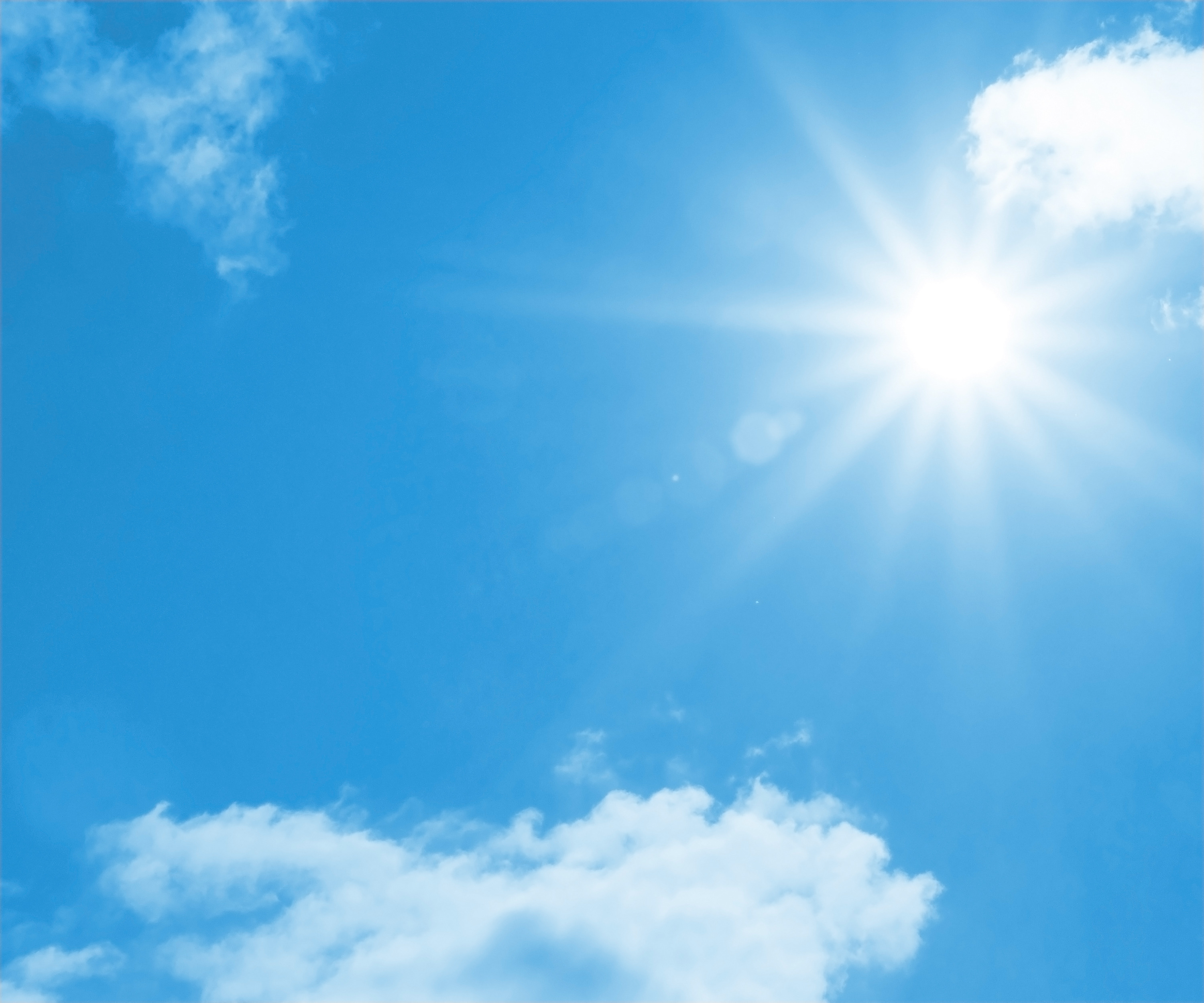 Bright blue sky with white clouds and a sunburst breaking through