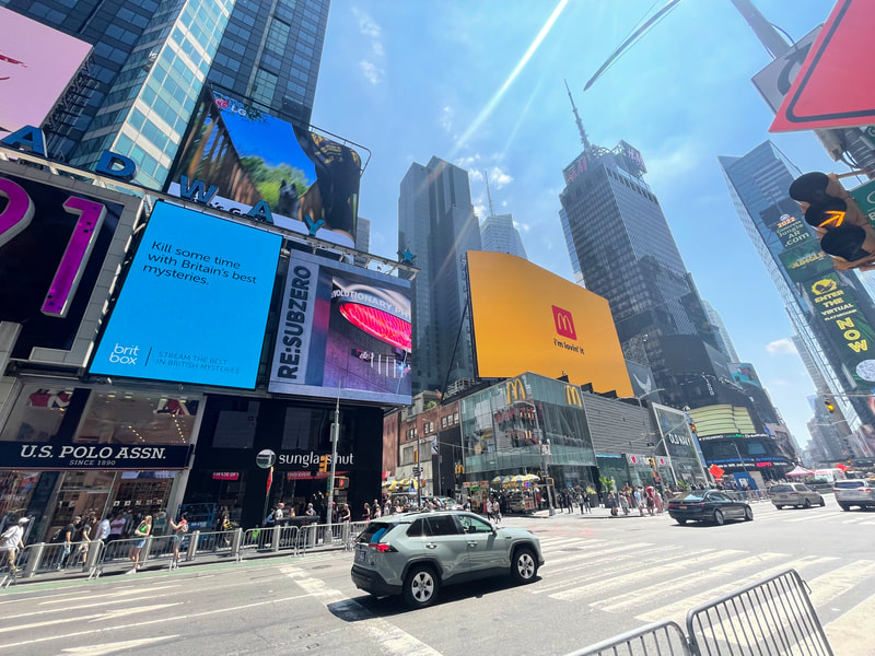Times Square wide view with BritBox digital billboard among multiple other screens
