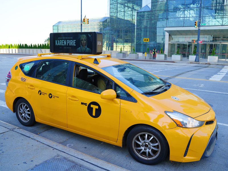 NYC yellow taxi with BritBox 'Karen Pirie' digital rooftop screen ad
