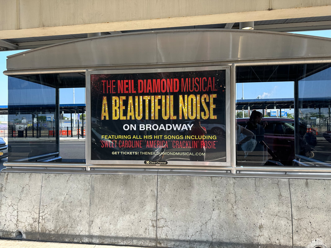 JFK airport bus shelter with 'A Beautiful Noise' Neil Diamond Musical outdoor poster