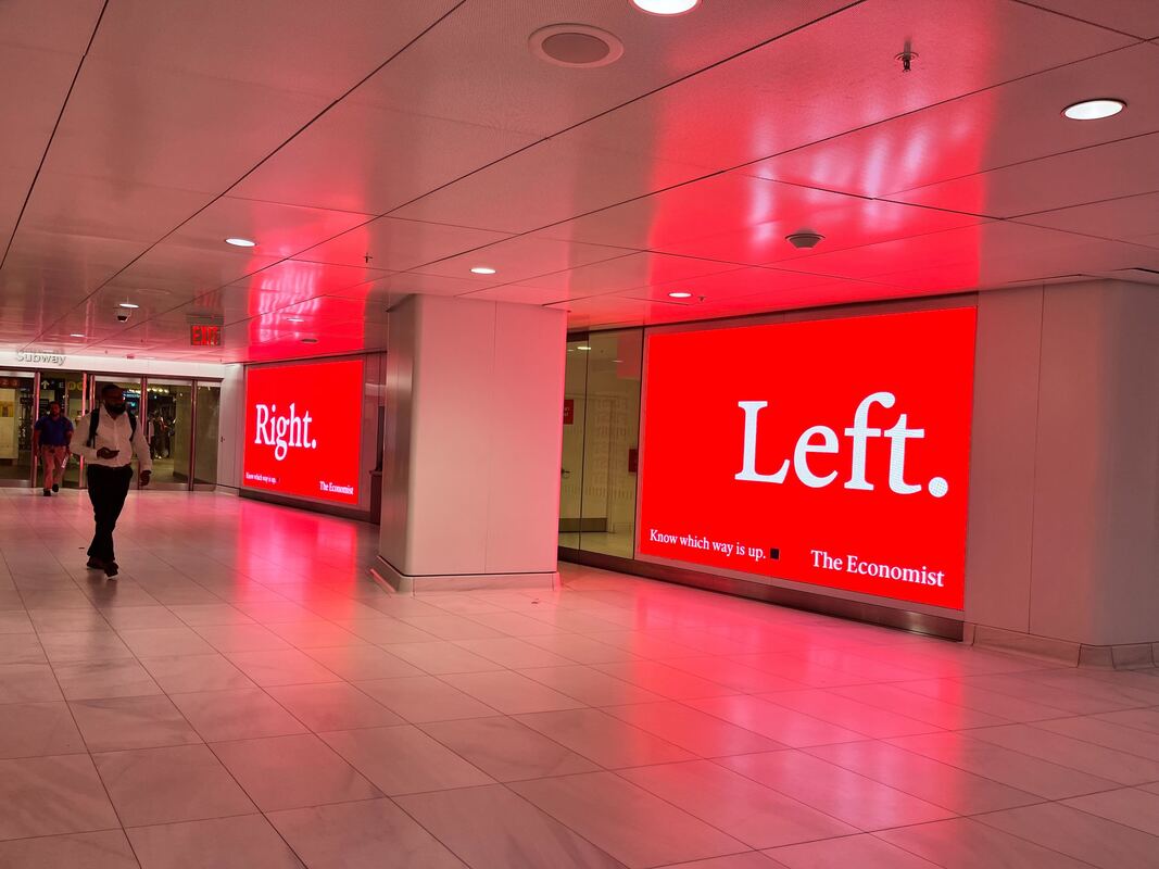 The Economist 'Right. Left.' red digital screens inside WTC corridor with pedestrians