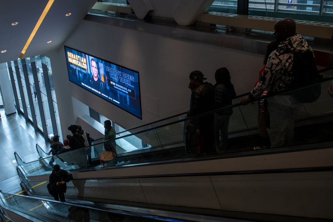 Sebastian Maniscalco horizontal LED screen at an escalator landing in Brooklyn Center arena