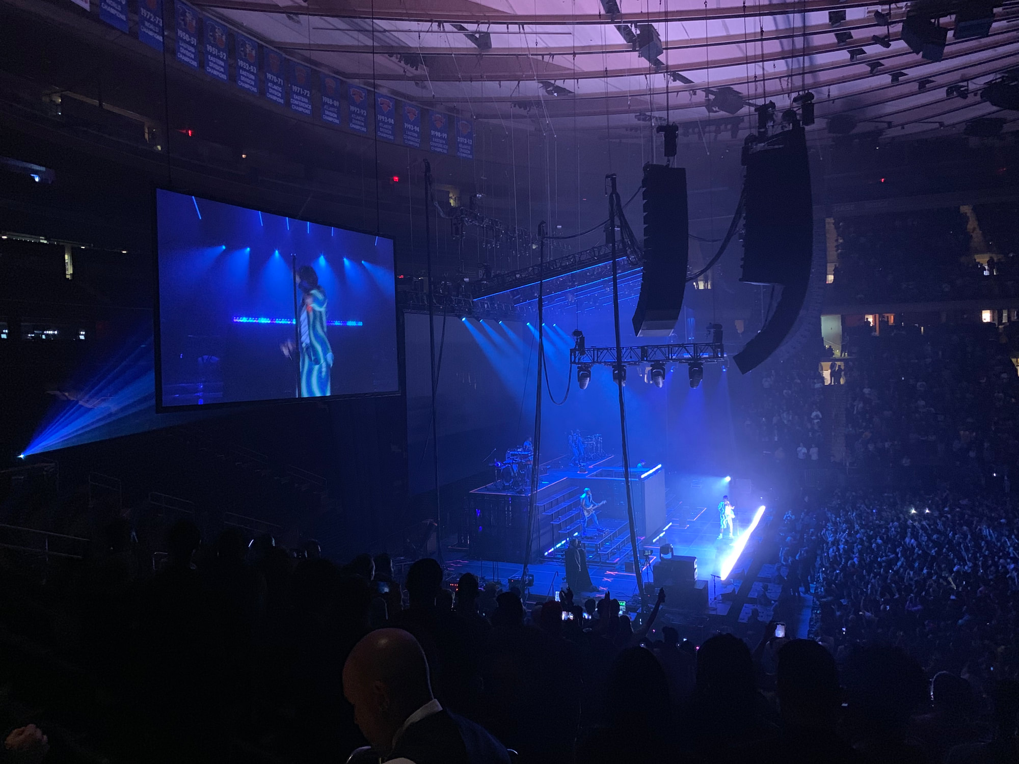 Concert at Madison Square Garden, performer on stage with blue lights and large crowd