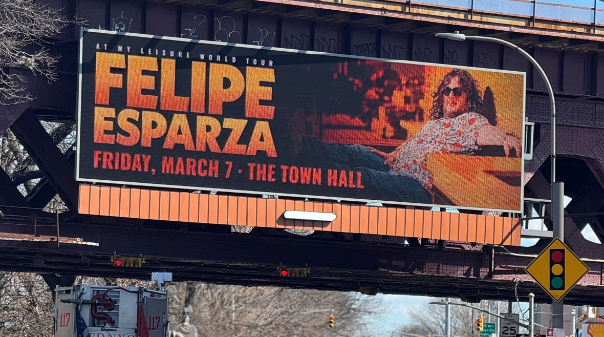 Felipe Esparza 'At My Leisure World Tour' billboard under an elevated train structure, NYC
