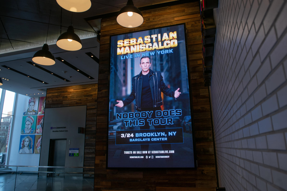 Sebastian Maniscalco vertical digital screen in Brooklyn Center venue lobby, close view