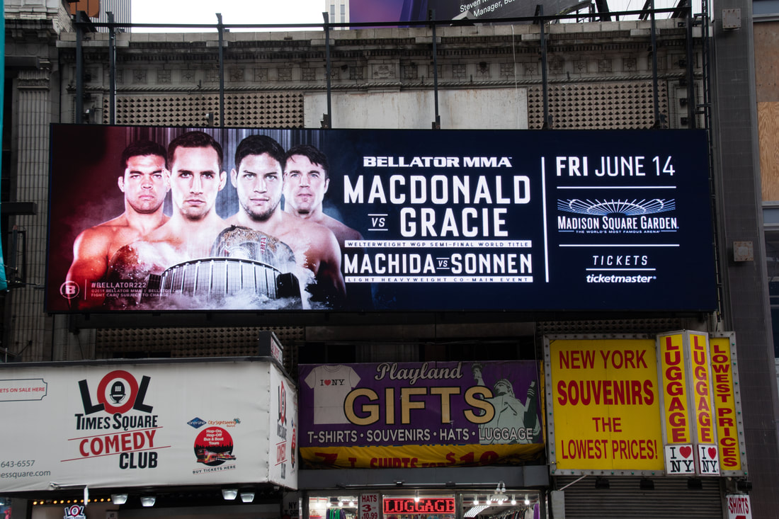 Bellator MMA Macdonald vs Gracie horizontal billboard above Times Square storefronts