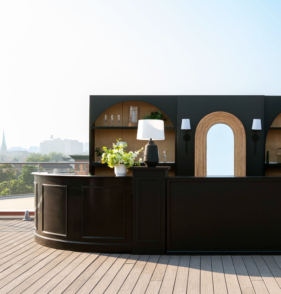 Close-up of a curved black bar with arch shelving on a rooftop deck