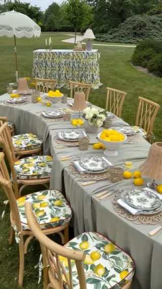 Outdoor garden tablescape with lemon-print linens and rattan chairs