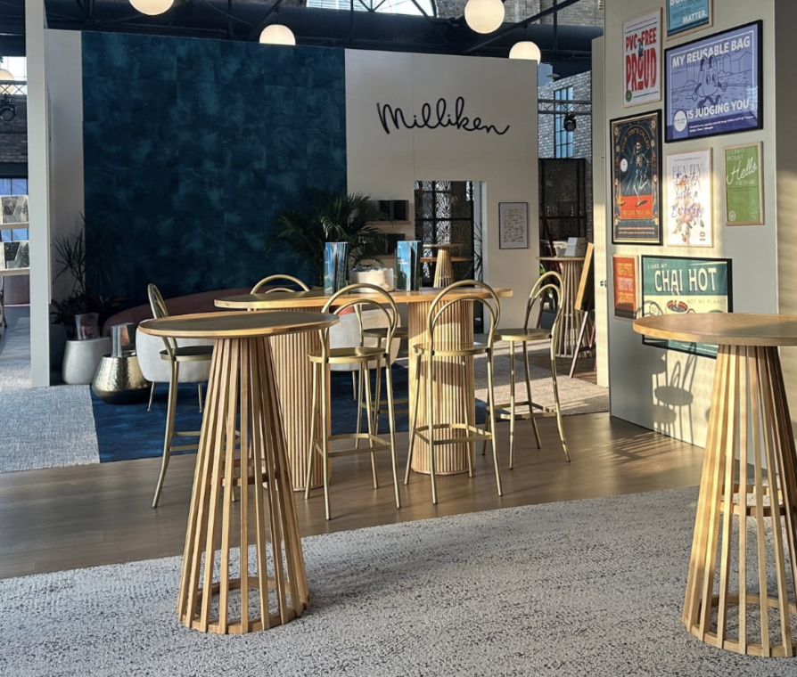 Branded Milliken trade show booth featuring rattan bar tables, stools and posters