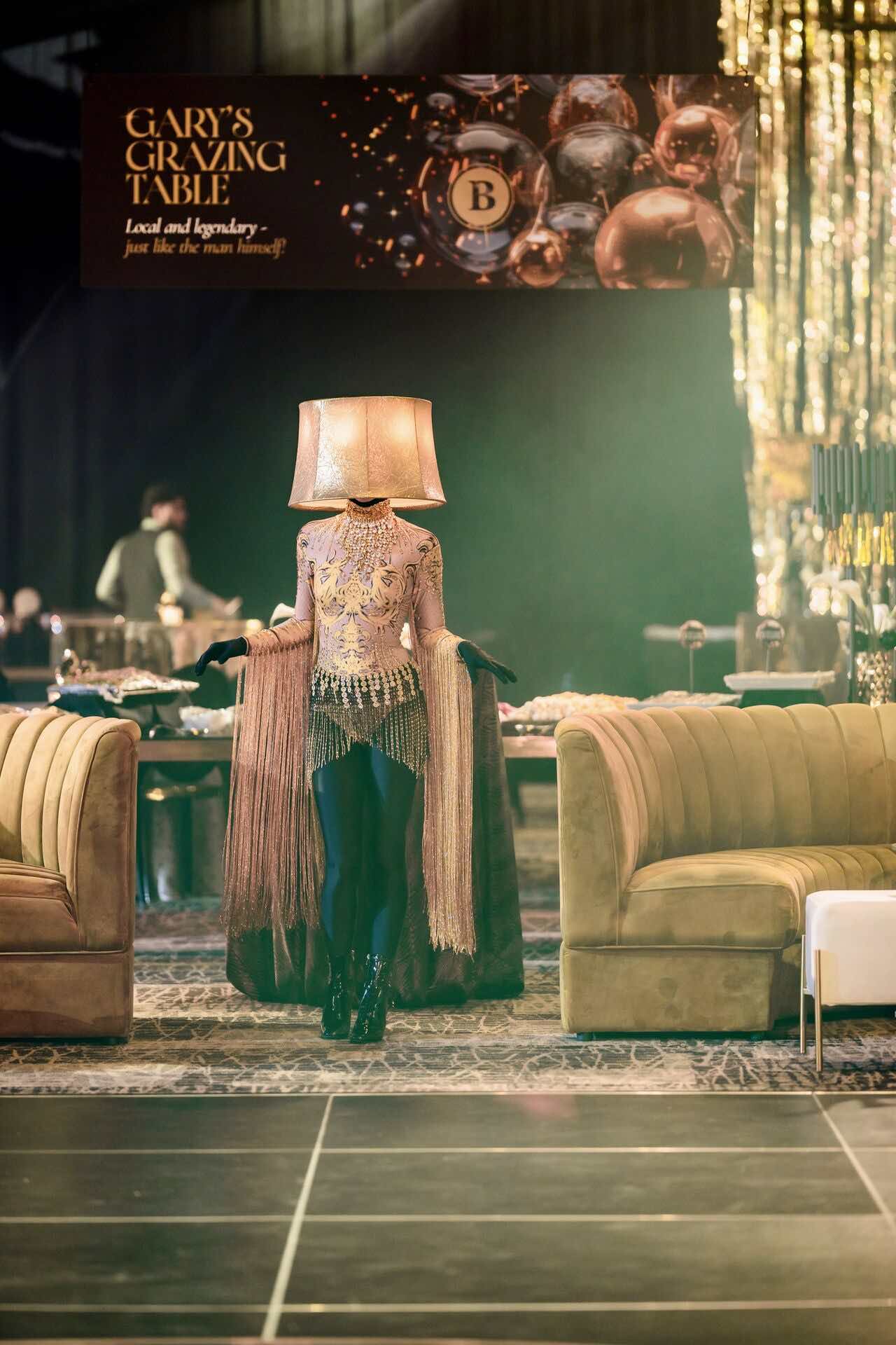 Branded event scene with gold Ophelia sofas beside 'Gary's Grazing Table' signage
