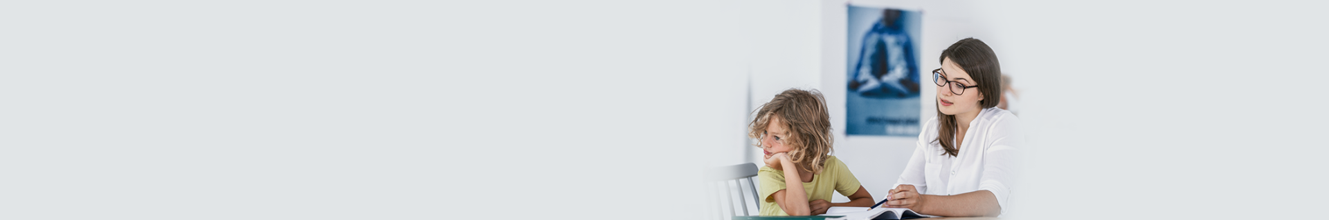 Female therapist reviewing a book with a young child at a table