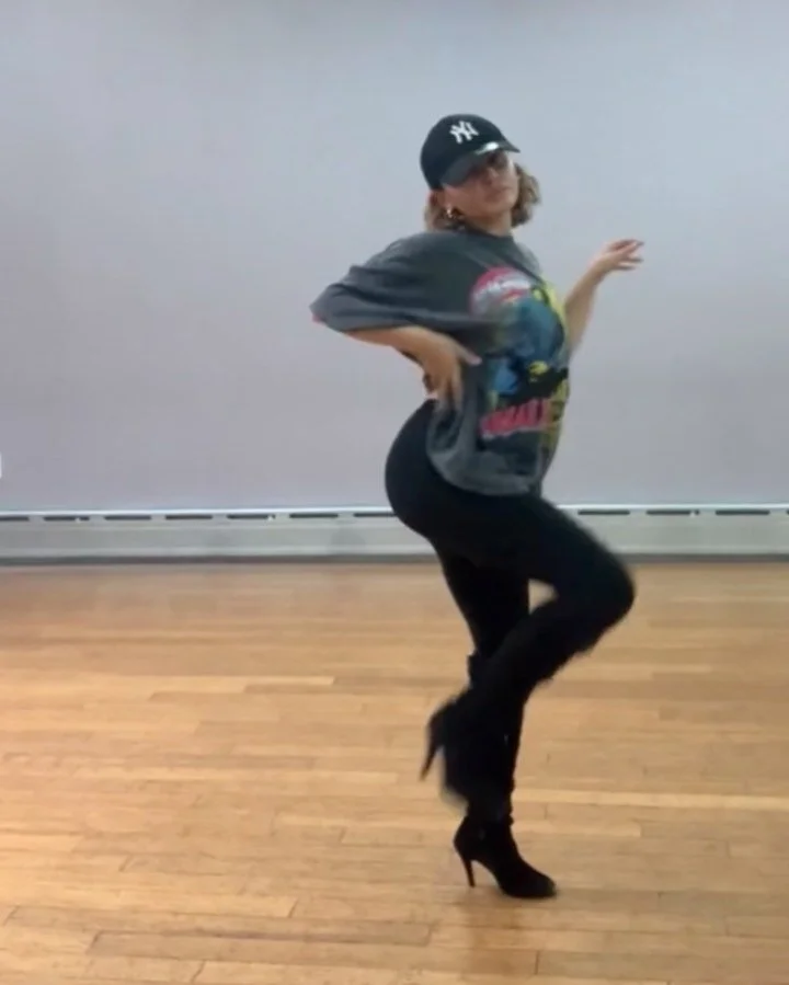 Dancer in Yankees cap and heeled boots in a mirrored studio