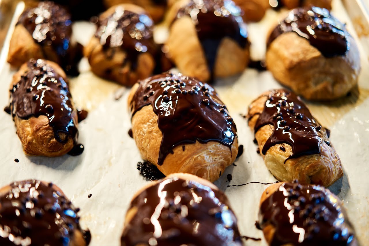 Chocolate-dipped croissants on a baking tray