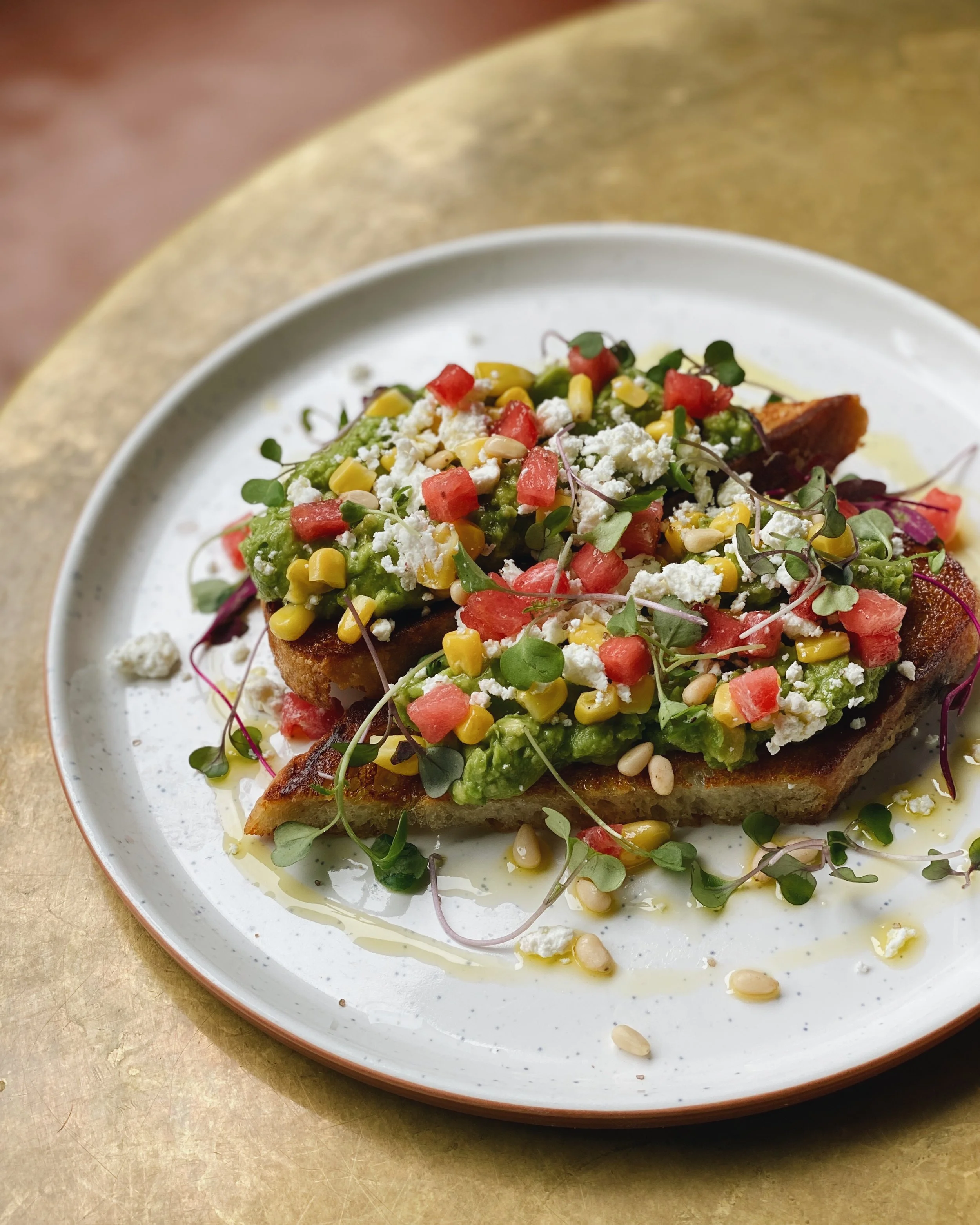 Avocado toast with watermelon, corn, feta and microgreens