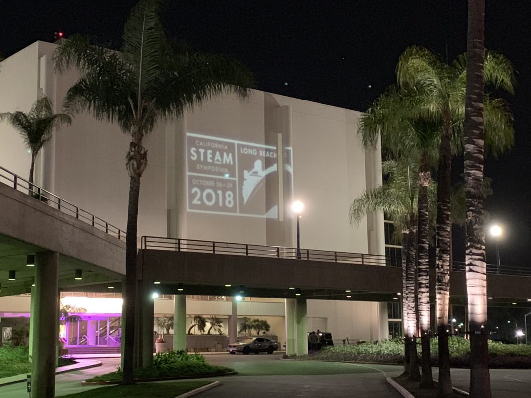 Convention center facade with California STEAM Symposium Long Beach 2018 projection mapping and palm trees