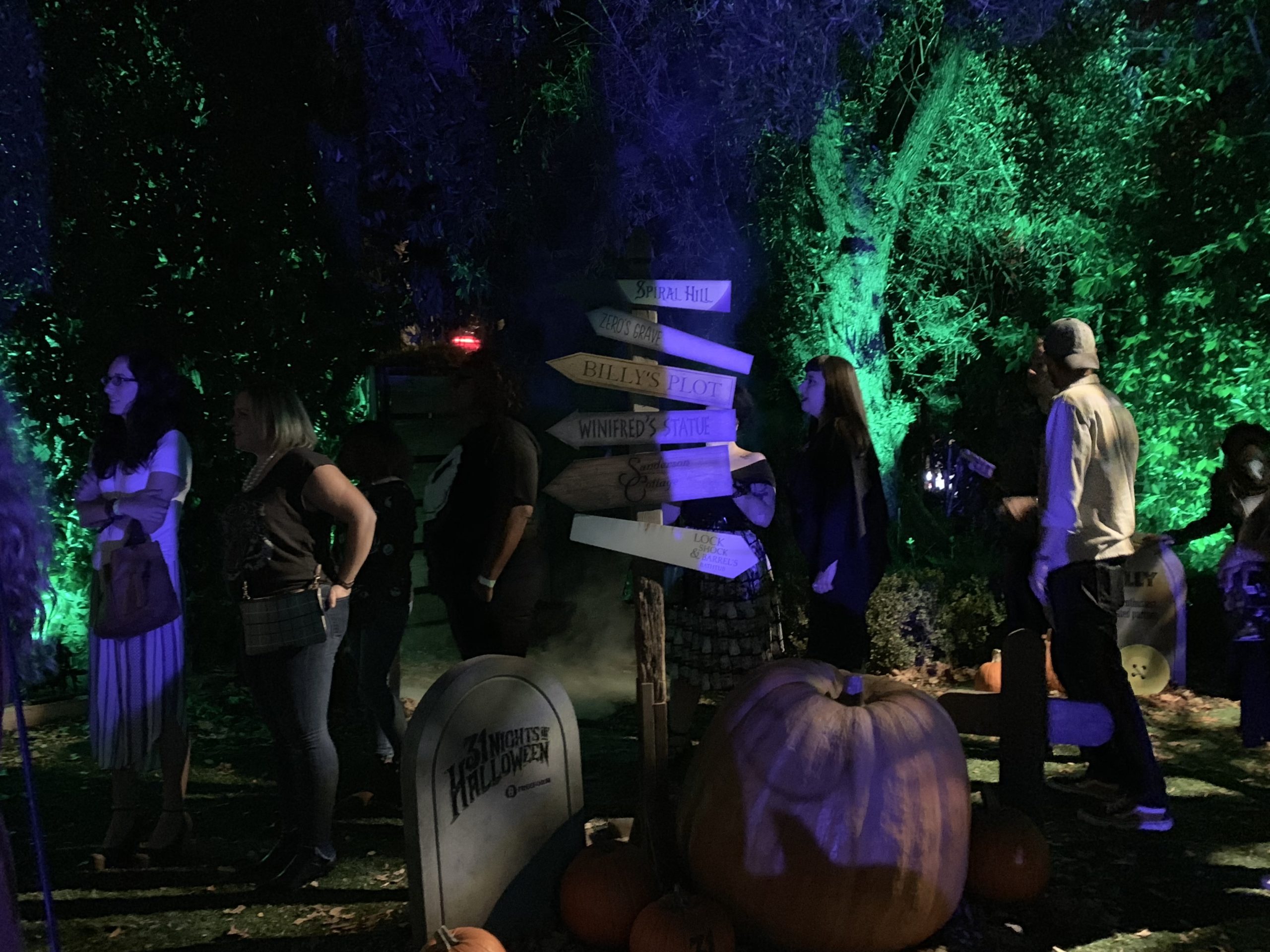 Nighttime Halloween experiential activation with a 31 Nights of Halloween tombstone and purple-lit pumpkins
