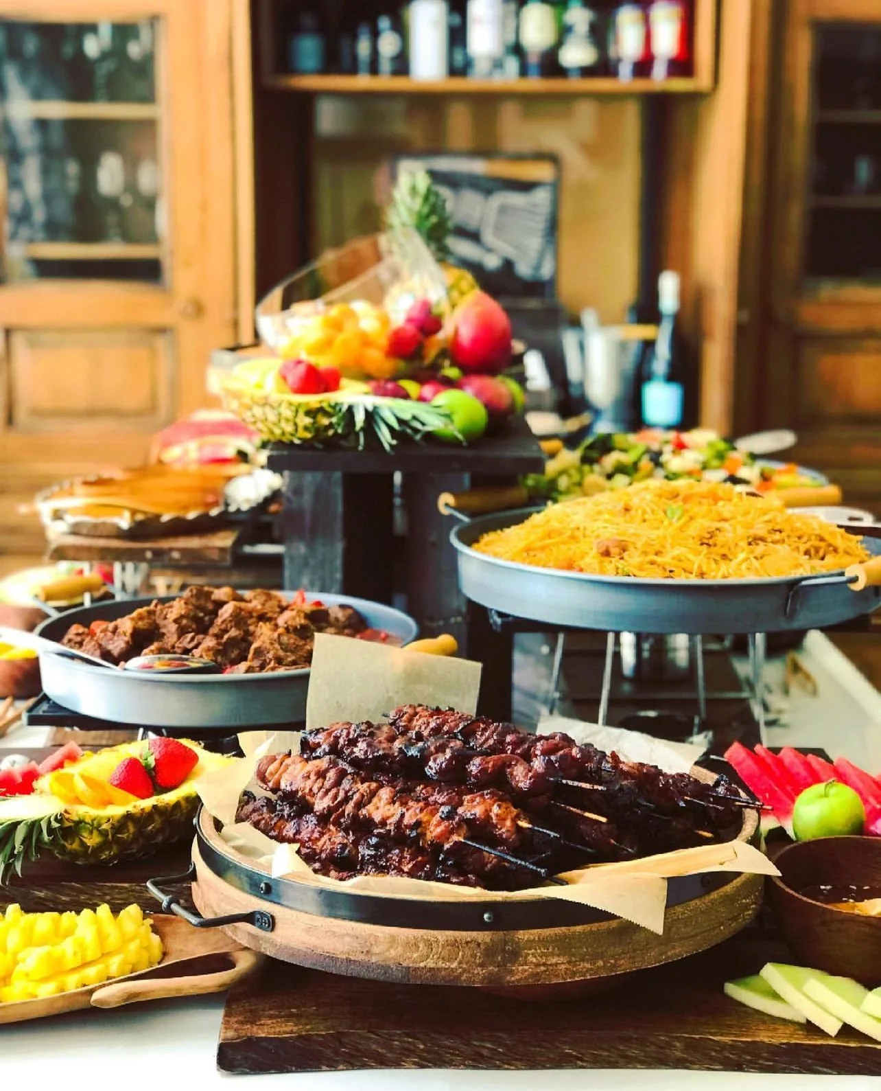 Large catering buffet with BBQ skewers and tropical fruit