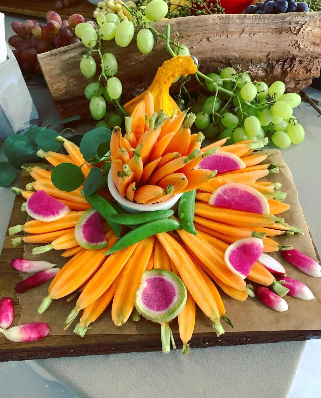 Radial sunburst crudité display on a wooden board
