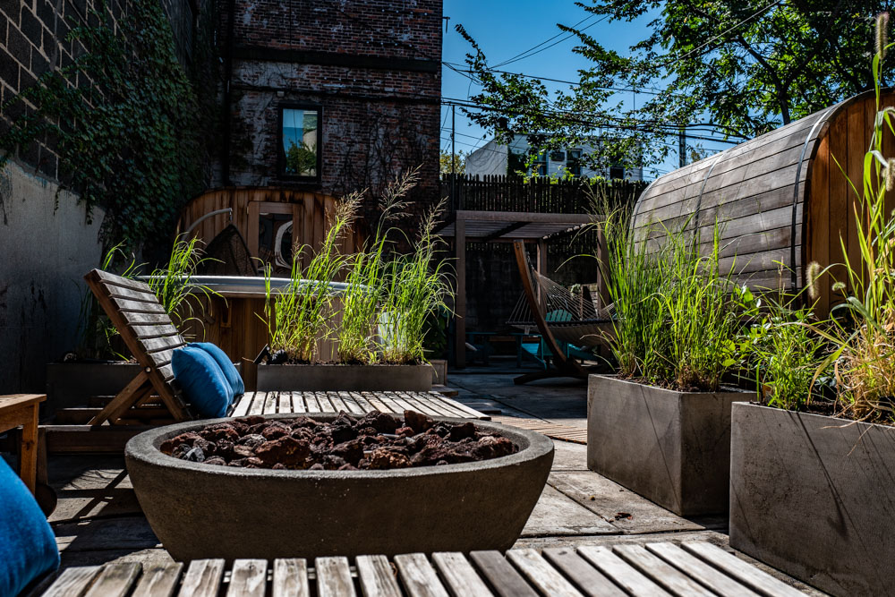cityWell outdoor courtyard with fire bowl, lounge chairs, barrel sauna and hammock